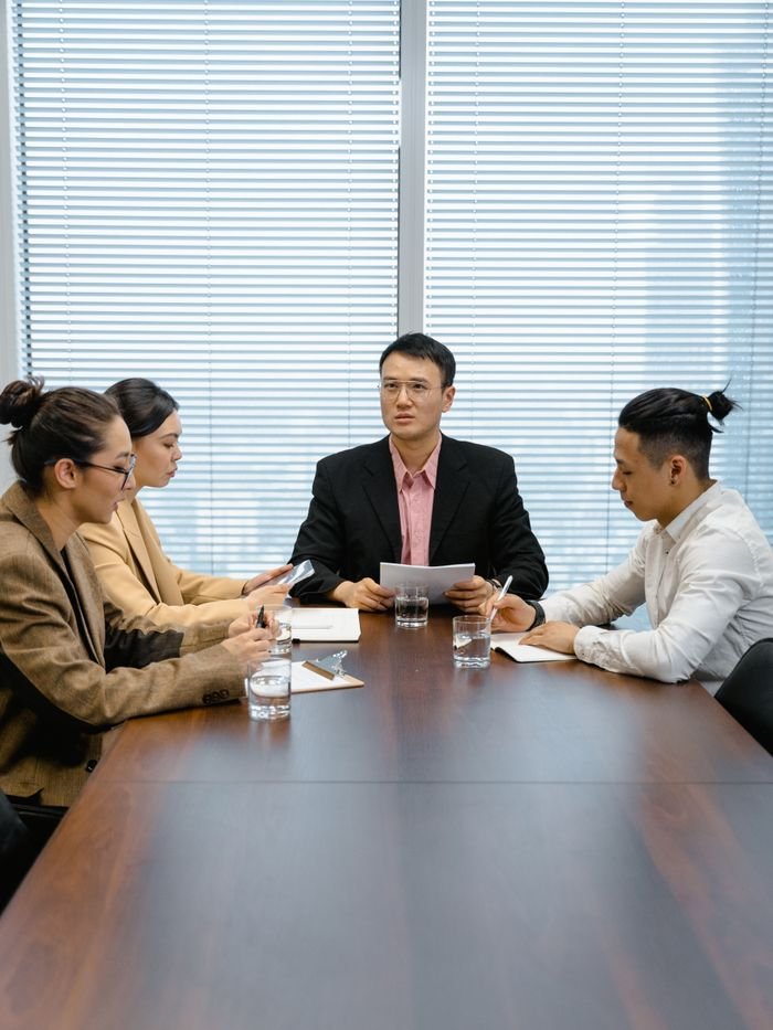 Group of professionals in a boardroom engaged in a focused business meeting.