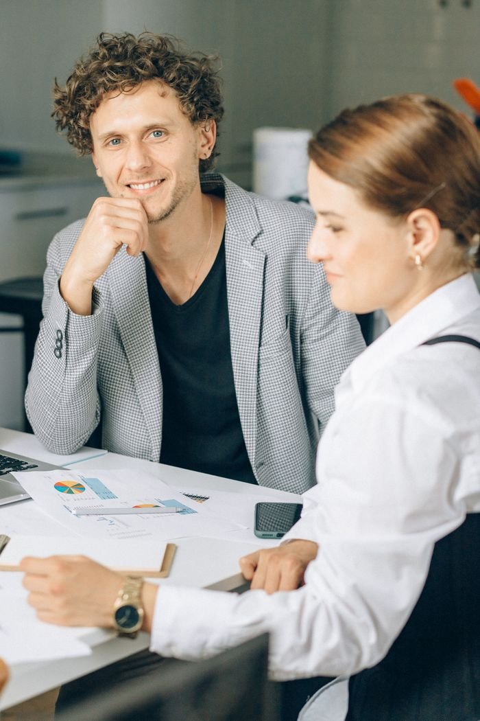 Two colleagues engaged in a business meeting in a modern office setting.